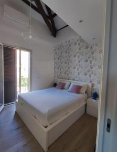 - une chambre avec un grand lit blanc et des oreillers roses dans l'établissement Casa Levante, à Isola delle Femmine