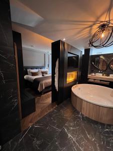 a large bathroom with a tub and a bed at Brabant Suites in Nistelrode