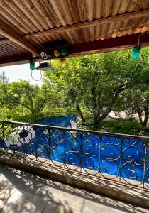 einen Balkon mit einem blauen Geländer mit Bäumen im Hintergrund in der Unterkunft Apple Tree Family Home (ECO) in Dzorakap