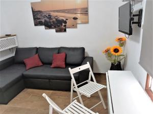 uma sala de estar com um sofá e duas cadeiras em Jema Apartamento Playa San Marcos by HRTenerife Net em Icod de los Vinos