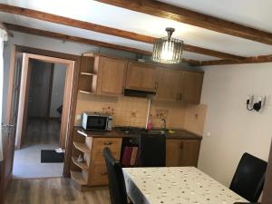 a small kitchen with a table and a microwave at Pensiunea Haiduc Sacele Brasov in Săcele