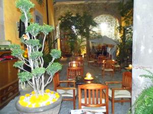 a restaurant with wooden chairs and tables and trees at Hotel Casa del Anticuario in Morelia