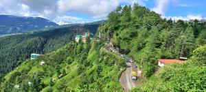 una strada tortuosa sul fianco di una montagna di Humble Holiday Inn Kufri Simla a Shimla