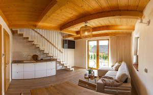 a living room with wooden ceilings and a staircase at Świerkowa Osada in Istebna