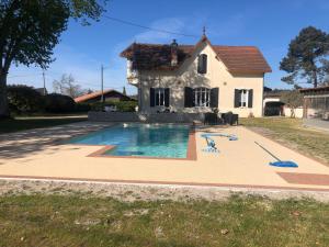 uma casa com piscina em frente a uma casa em Chambres d´hotes VILLA CAPSYLVAINE em Captieux