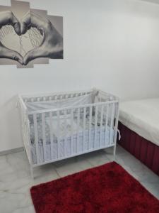a baby crib with a heart picture on the wall at Apartmani Parice in Novi Pazar