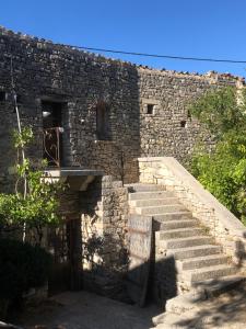 un edificio de piedra con escaleras delante en La Tour des Baronnies à la Porte de l eau, en Saint-Auban-sur-Ouvèze