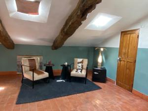 sala de estar con 2 sillas y techo con vigas. en La Tour des Baronnies à la Porte de l eau, en Saint-Auban-sur-Ouvèze
