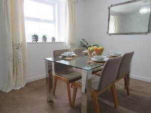 a dining room table with chairs and a mirror at Marr Cottage in Thornhill