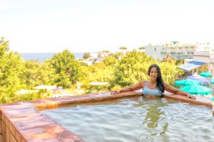 a woman is standing in a swimming pool at Bristol Hotel in Ischia