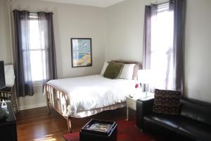 a bedroom with a bed and a couch and windows at Modern Homestead Guest House in Reedsville