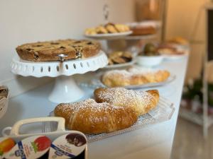 a table with various pastries and pies on display at La Perla del Borgo B&B in Pisa
