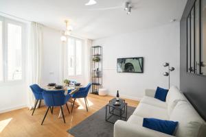 uma sala de estar com um sofá e uma mesa com cadeiras azuis em HeavnStay Suite 2 Cannes Centre em Cannes