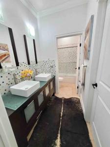ein Badezimmer mit zwei Waschbecken und einem Spiegel in der Unterkunft Luxury mansion with pool jacuzzi BBQ for ultimate scape in Tamiami