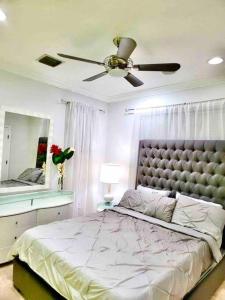 ein Schlafzimmer mit einem Bett und einem Deckenventilator in der Unterkunft Luxury mansion with pool jacuzzi BBQ for ultimate scape in Tamiami