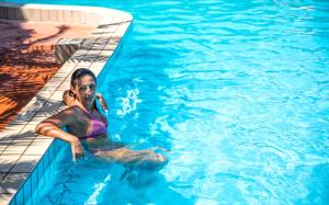 a woman is sitting in a swimming pool at Bristol Hotel in Ischia
