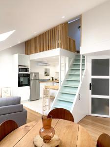 Il comprend une cuisine et un salon avec un escalier et une table. dans l'établissement Appartement au centre de Toulouse, à Toulouse