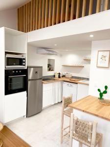 - une cuisine avec des appareils blancs et une table en bois dans l'établissement Appartement au centre de Toulouse, à Toulouse