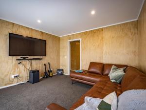 ein Wohnzimmer mit Couch und Flachbildfernseher in der Unterkunft Manawa - Ohakune Holiday Home in Ohakune