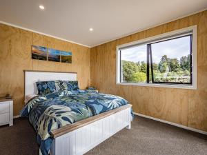 ein Schlafzimmer mit einem Bett und einem Fenster in der Unterkunft Manawa - Ohakune Holiday Home in Ohakune