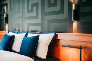 - une chambre avec un lit doté d'oreillers bleus et blancs dans l'établissement DAS v EVERT Hotel - am Congress Centrum Würzburg, à Wurtzbourg