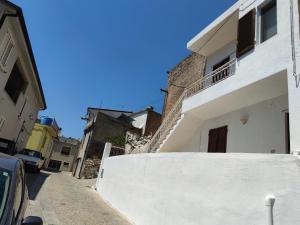 een straat met een wit gebouw en een auto bij Sa Dommu 'e su coro in Triei
