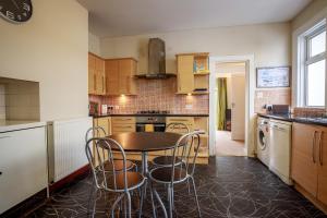 a kitchen with a table and chairs in it at Amazing views across the Moray Firth, Private Suntrap Patio, 300m from the Beach, off street parking! in Nairn