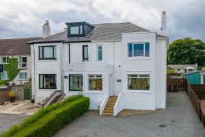 a white house with a staircase in front of it at Amazing views across the Moray Firth, Private Suntrap Patio, 300m from the Beach, off street parking! in Nairn