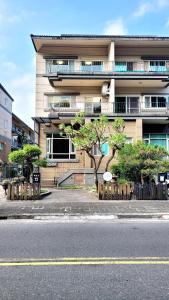 ein Gebäude mit einem Baum vor einer Straße in der Unterkunft 杉羽松民宿 Seeing A Song INN in Luodong