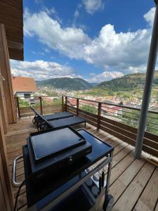 einen Balkon mit 2 Tischen und Stadtblick in der Unterkunft Magnifique appartement classé 4 étoiles avec Sauna et terrasse dans chalet in La Bresse