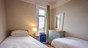 a bedroom with two beds next to a window at Amazing views across the Moray Firth, Private Suntrap Patio, 300m from the Beach, off street parking! in Nairn