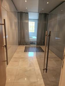 ウィーンにあるElegant Cozy Apartmentのシャワーとタイル張りの床を備えたバスルーム +8枚の写真