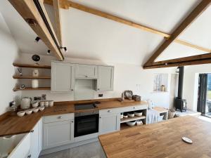 a kitchen with white cabinets and a wooden counter top at The Old Parlour - With Hot tub and Dog Friendly! in Selby