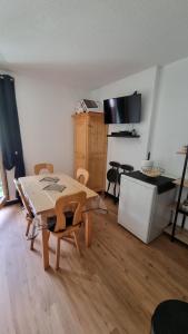 a living room with a table and a kitchen at Appartement de station rénovée avec parking in Habère-Poche