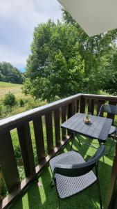 - un balcon avec une table et deux chaises dans l'établissement Appartement de station rénovée avec parking, à Habère-Poche