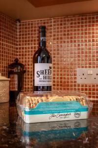 a bottle of wine sitting on top of a box at Amazing views across the Moray Firth, Private Suntrap Patio, 300m from the Beach, off street parking! in Nairn