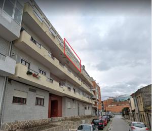 um edifício com carros estacionados ao lado dele em Portela - APARTAMENTO em Viana do Castelo