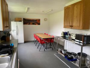 uma cozinha com uma mesa e cadeiras vermelhas em The Bunkhouse em Applecross