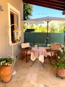 un patio con mesa y sombrilla en Corte dei Mirti, camere signorili, en Iglesias