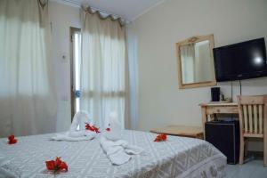 a hotel room with towels on a bed with a mirror at Hotel L'Oleandro in Villasimius