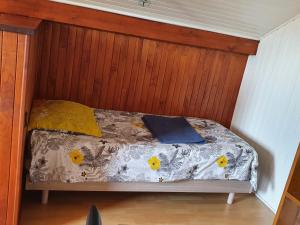ein kleines Bett in einem Zimmer mit Holzvertäfelung in der Unterkunft Chez Gilles et Eveline in Cruet
