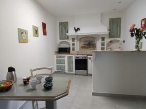 cocina con electrodomésticos blancos y mesa con mesa en Gite d'Emma, en Camaret-sur-Aigues
