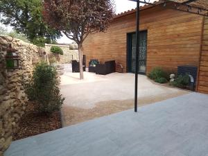 a patio of a house with a stone wall at Gite d'Emma in Camaret-sur-Aigues +15 photos