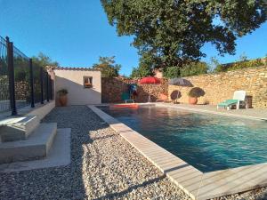 una piscina en un patio con una pared de piedra en Gite d'Emma, en Camaret-sur-Aigues