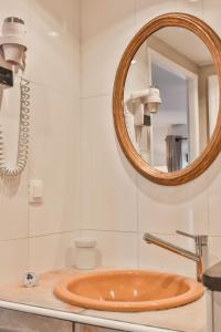 y baño con lavabo y espejo. en Maison d'hôtes Le Hameau de la Mûre, en Saint-Laurent-du-Pape