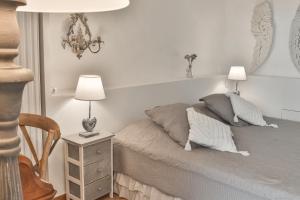 1 dormitorio con 1 cama con 2 lámparas y mesita de noche en Maison d'hôtes Le Hameau de la Mûre, en Saint-Laurent-du-Pape