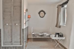 una habitación blanca con una mesa con platos. en Maison d'hôtes Le Hameau de la Mûre, en Saint-Laurent-du-Pape