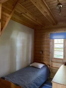 TammijärviにあるNenäniemiの木造キャビン内のベッド1台が備わるベッドルーム1室を利用します。