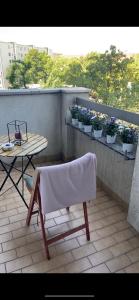 a chair on a balcony with a table and potted plants at Hubert in Berlin