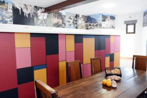 a dining room with a table and a colorful wall at Hostel Rural Gaitanes, Caminito del Rey, Ardales in Ardales